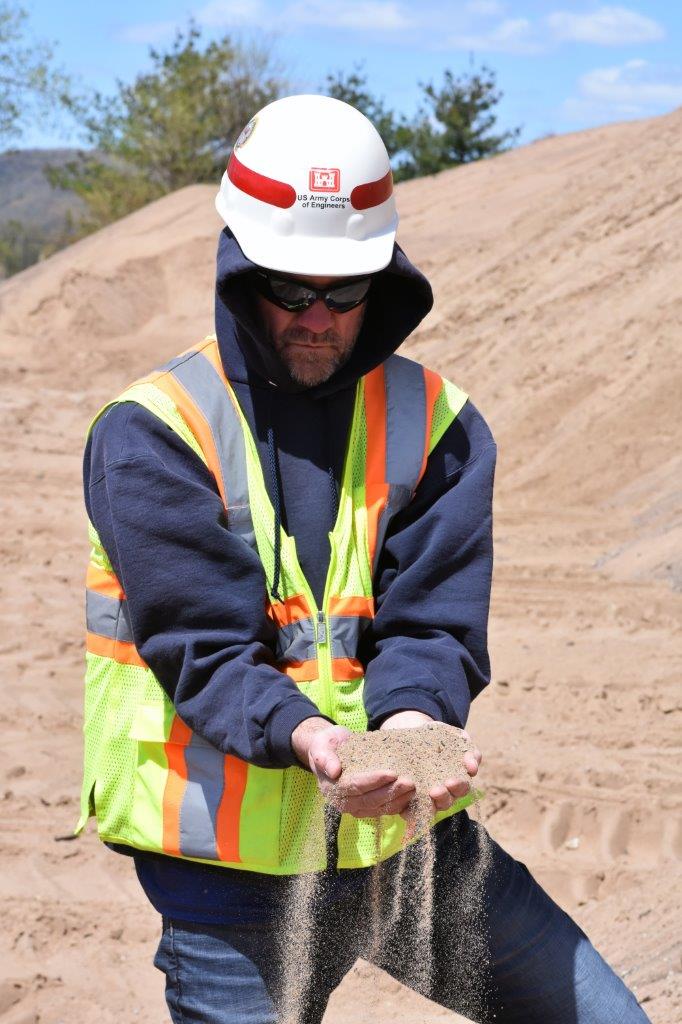 Man reviews dredged material
